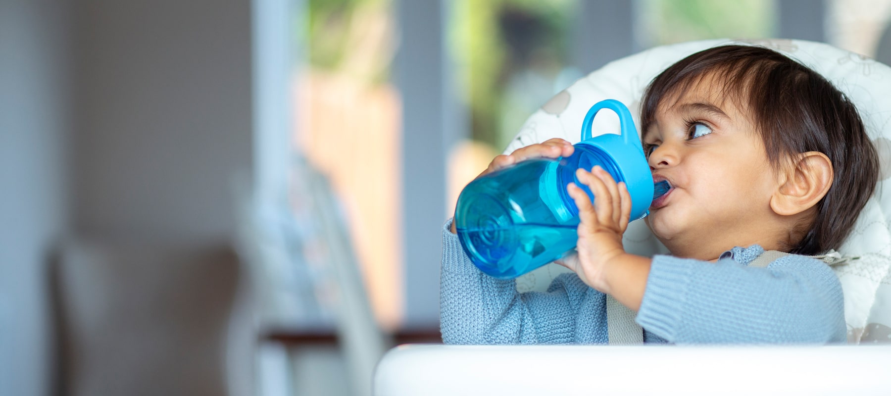 Child drinking vapor distilled water from a sippy cup