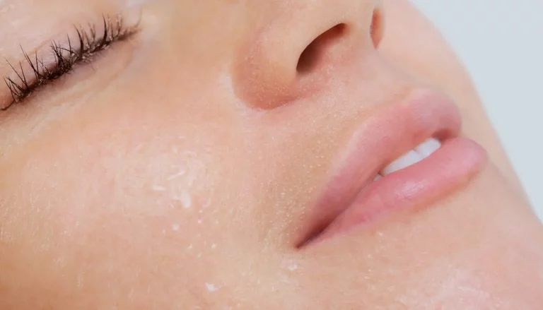 A close up shot of the face of a young woman enjoying a steam facial.